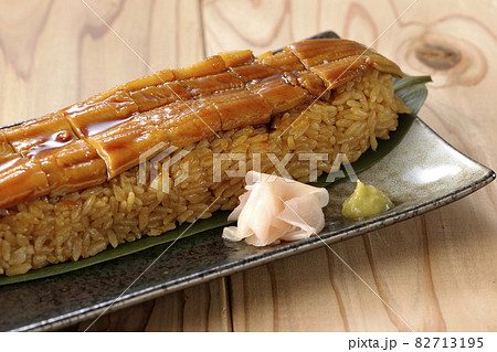 笹の葉に置かれた穴子の姿鮨とガリと山葵 82713195