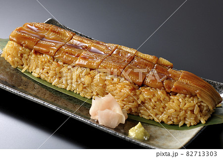 笹の葉に置かれた穴子の姿鮨とガリと山葵を黒背景で撮影 82713303