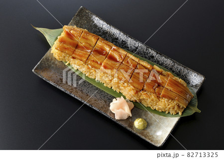 笹の葉に置かれた穴子の姿鮨とガリと山葵を黒背景で俯瞰撮影 82713325