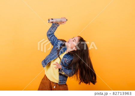 Cute little girl wearing bright stylish clothes on yellow colorful background Cute little girl wearing bright stylish clothes on yellow colorful background 82713963