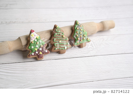 Gingerbread cookies of green Christmas tree on white wood background. 82714122