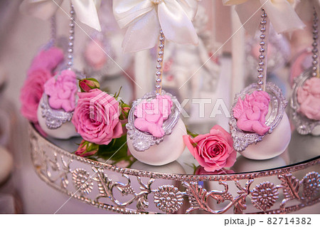 Delicious desserts at the wedding candy bar in the buffet area: cake pops decorated with angels and cameo and fresh rosebuds. Delicious desserts at the wedding candy bar in the buffet area: cake pops decorated with angels and cameo and fresh rosebuds. 82714382