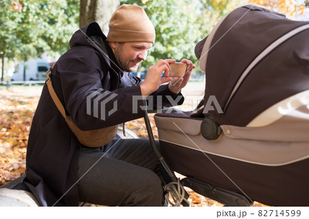 Father with baby In Park taking a photo by mobile phone 82714599