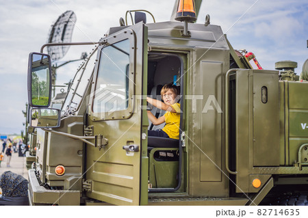 A little boy is studying military equipment. No war 82714635