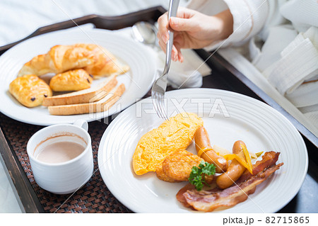 Close up woman enjoy breakfast on a bed in bedroom Close up woman enjoy breakfast on a bed in bedroom 82715865