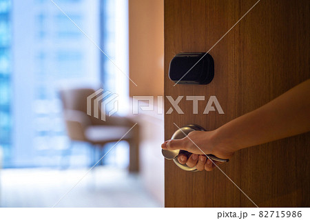 Female hand grabbing doorknob opening room for access, selective focused 82715986