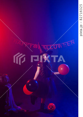 Funny child girl in witch costume for Halloween with pumpkin Jack. Funny child girl in witch costume for Halloween with pumpkin Jack. 82716325