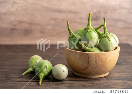 Green eggplant fresh vegetable in wooden bowl with copy space. Green eggplant fresh vegetable in wooden bowl with copy space. 82718315