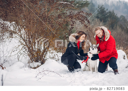 Beautiful couple playing with a dog 82719083
