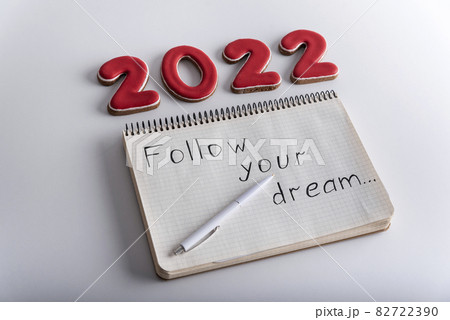 Numbers 2022 and notebook with words: FOLLOW YOUR DREAM. Wishlist for 2022 82722390