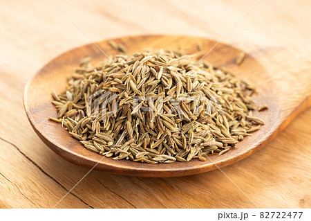 Cumin seeds on wooden spoon on table. Cuminum cyminum Cumin seeds on wooden spoon on table. Cuminum cyminum 82722477