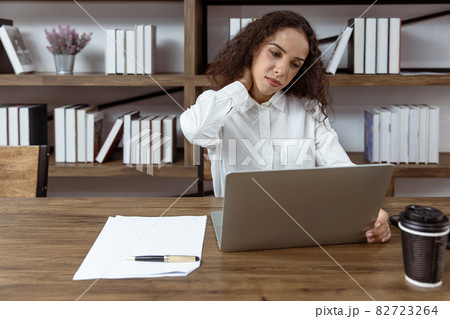 Women worker  self massage suffering from neck pain and office syndrome 82723264