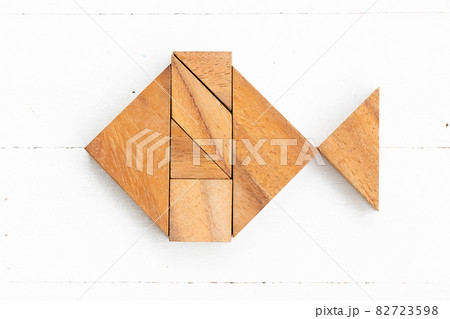 Wood tangram puzzle in fish shape on white wood background 82723598