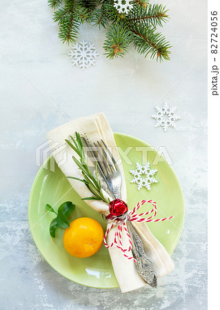 Decor Christmas table on stone background. Green plate, cutlery and decorations. Top view. 82724056