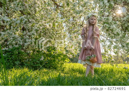 A girl sniffs a beautiful white apple tree, spring in the midst of the flowering of the apple tree is beautiful apple kid flower beauty tree, model attractive. Pretty wellness pink, light woman meadow A girl sniffs a beautiful white apple tree, spring in the midst of the flowering of the apple tree is beautiful apple kid flower beauty tree, model attractive. Pretty wellness pink, light woman meadow 82724691