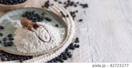 Plate with black beans flour with a wooden scoop 82725277