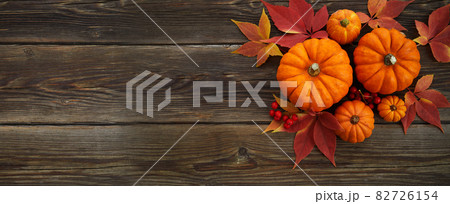 Framework with pumpkins and fall leaves on wooden background. Top view. 82726154