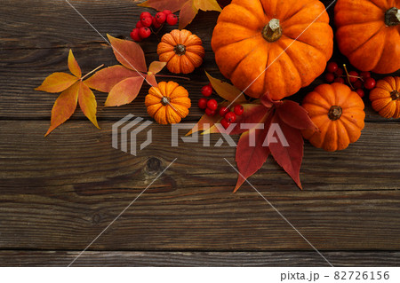 Framework with pumpkins and fall leaves on wooden background. Top view. 82726156