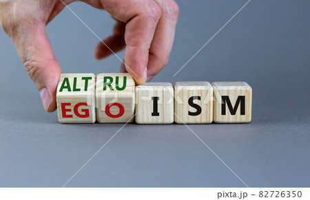 Altruism or egoism symbol. Businessman turns wooden cubes and changes the word 'egoism' to 'altruism'. Beautiful grey background, copy space. Business, psychological and altruism or egoism concept. Altruism or egoism symbol. Businessman turns wooden cubes and changes the word 'egoism' to 'altruism'. Beautiful grey background, copy space. Business, psychological and altruism or egoism concept. 82726350