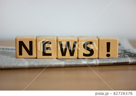 Cubes placed on a newspaper form the word 'news'. Beautiful wooden table. White background. Business concept. Copy space. Cubes placed on a newspaper form the word 'news'. Beautiful wooden table. White background. Business concept. Copy space. 82726376