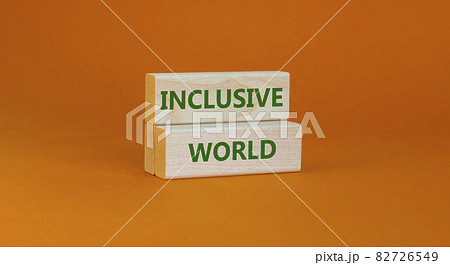 Inclusive world symbol. Wooden blocks with words Inclusive world on beautiful orange background. Business, inclusive world concept. Copy space. 82726549