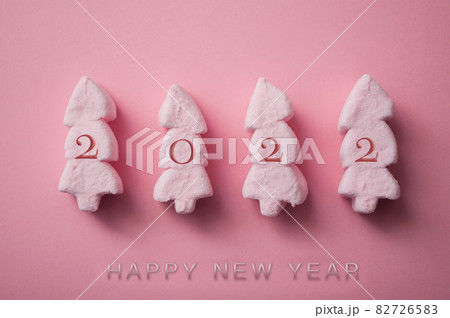 closeup of pink marshmallows in shaped fir on pink background - happy new year 2022 card closeup of pink marshmallows in shaped fir on pink background - happy new year 2022 card 82726583