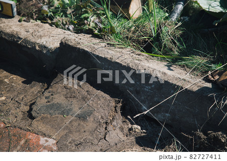 Men lay curbstone for grouting garden path, construction work on garden plot 82727411
