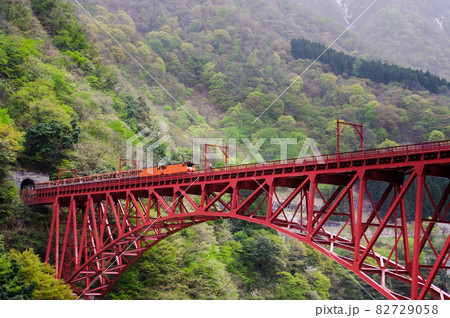 赤い鉄橋を走る黒部渓谷のトロッコ列車 82729058