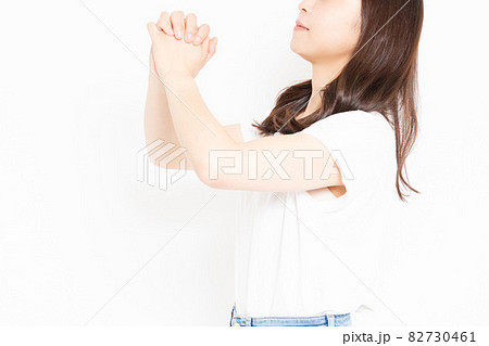 お願いのジェスチャーをするTシャツを着た若い女性 お願いのジェスチャーをするTシャツを着た若い女性 82730461