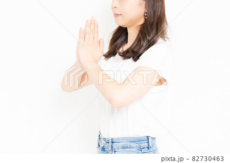 お願いのジェスチャーをするTシャツを着た若い女性 お願いのジェスチャーをするTシャツを着た若い女性 82730463