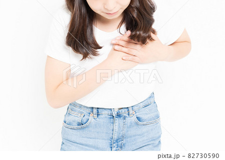 胸に手を当てるTシャツを着ている若い女性 82730590