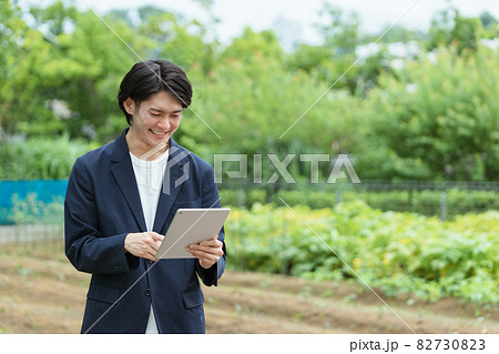 畑を管理する若い男性・ITとAIの活用 82730823