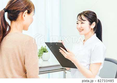 診察を受ける中高年の女性と医療スタッフ 診察を受ける中高年の女性と医療スタッフ 82733485