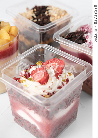 take away trifle cake in a box. red velvet sponge bisquit with mascarpone and berry jam filling. sublimated strawberry and pistachios nuts topping. autumn season sweet treats. 82733539