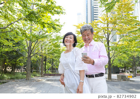 品川を散歩しながら仲良くくっついて会話するシニアカップル 82734902