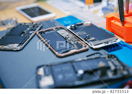 Phone repair concept several electronic devices taken apart into the components like the covers, circuit boards, bodies 82735313