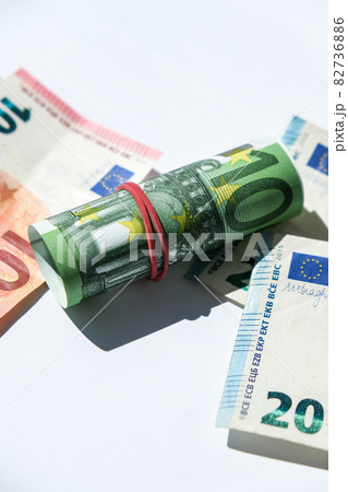 Close up of Euro money roll. Euro banknote set cash money - EU currency. Rolled with rubber euro notes. Banknotes stacked on each other in different positions Close up of Euro money roll. Euro banknote set cash money - EU currency. Rolled with rubber euro notes. Banknotes stacked on each other in different positions 82736886
