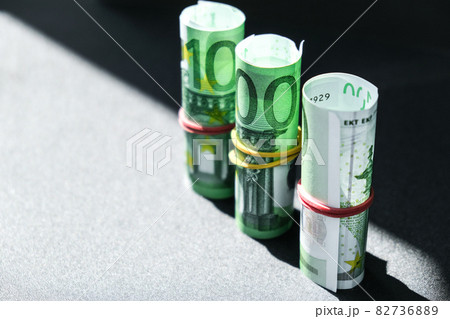 Close up of Euro money roll. Euro banknote set cash money - EU currency. Rolled with rubber euro notes. Banknotes stacked on each other in different positions Close up of Euro money roll. Euro banknote set cash money - EU currency. Rolled with rubber euro notes. Banknotes stacked on each other in different positions 82736889