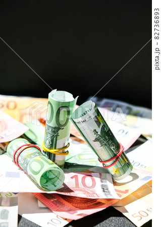 Close up of Euro money roll. Euro banknote set cash money - EU currency. Rolled with rubber euro notes. Banknotes stacked on each other in different positions 82736893