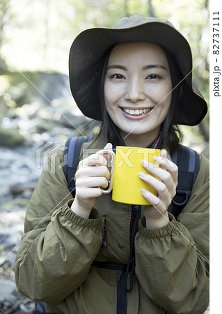 飲み物を飲んで休憩をする女性 トレッキングイメージ 飲み物を飲んで休憩をする女性 トレッキングイメージ 82737111
