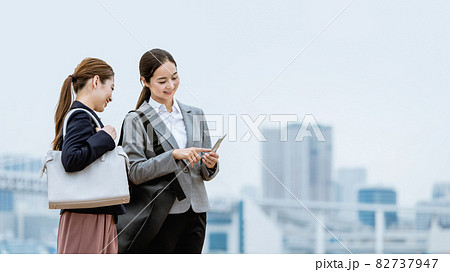 スマートフォンを見せ合う2人の女性 スマートフォンを見せ合う2人の女性 82737947