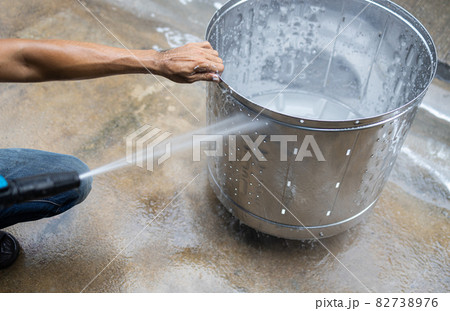 Rinse the laundry tub with cleaning disinfectant solution or detergent,cleaning the washing machine tub to remove dirt stuck,mold,algae stains and bacteria buildup,cleanliness and Hygiene concept 82738976