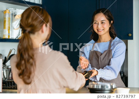 カフェでスマホ決済をする女性（飲食店・テイクアウト） 82739797