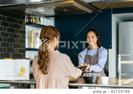 カフェでスマホ決済をする女性（飲食店・テイクアウト） 82739799