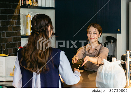 カフェでスマホ決済をする女性（飲食店・テイクアウト） 82739802