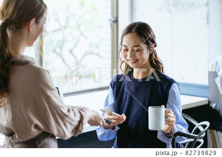カフェ（コワーキングスペース）でスマホ決済をする女性 82739829