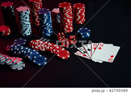 Casino chips and cards on black table surface. Gambling, fortune, game and entertainment concept - close up Casino chips and cards on black table surface. Gambling, fortune, game and entertainment concept - close up 82740369