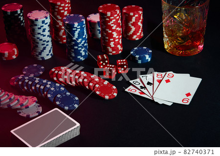 Cards of poker player. On the table are chips and a glass of cocktail with whiskey. Combination of cards Cards of poker player. On the table are chips and a glass of cocktail with whiskey. Combination of cards 82740371