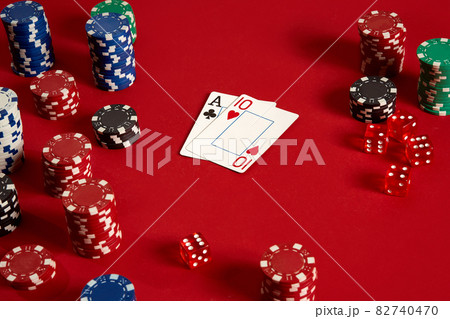 Two cards and chips on a red background. Big bet of game money. Cards - Ace and Ten. Your distribution at the table 82740470