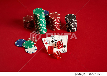 Two cards and chips on a red background. Big bet of game money. Cards - Ace and Ten. Your distribution at the table Two cards and chips on a red background. Big bet of game money. Cards - Ace and Ten. Your distribution at the table 82740758
